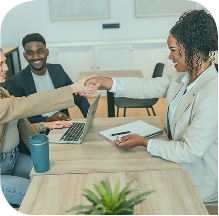 Clairs Keeley Lawyers, Perth: Professionals shaking hands over a desk with a laptop, symbolizing partnership in legal matters.
