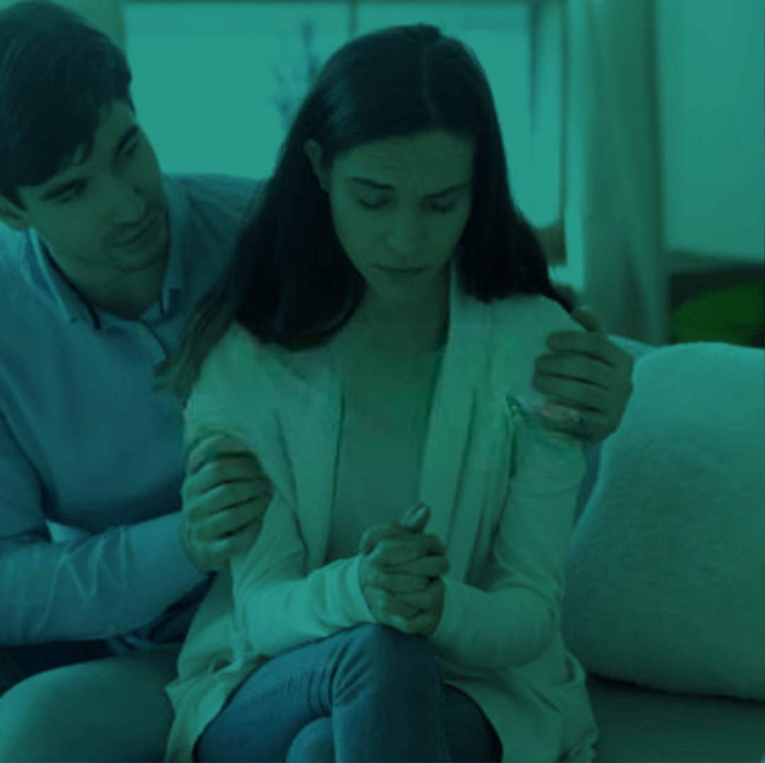 De Facto Relationships: Couple seeking Family Law advice in Perth. He comforts her with a hand on her shoulder, a symbol of support during legal matters.