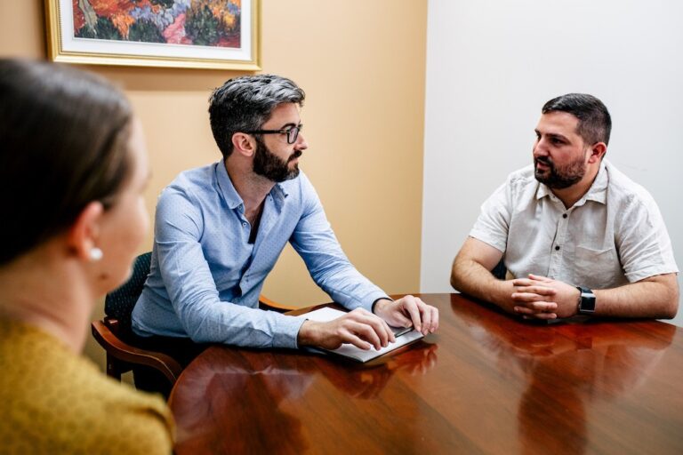 De facto relationships meeting in Perth at Clairs Keeley Lawyers. Lawyers Ben and Ebony consult at a desk. Family & Commercial Law