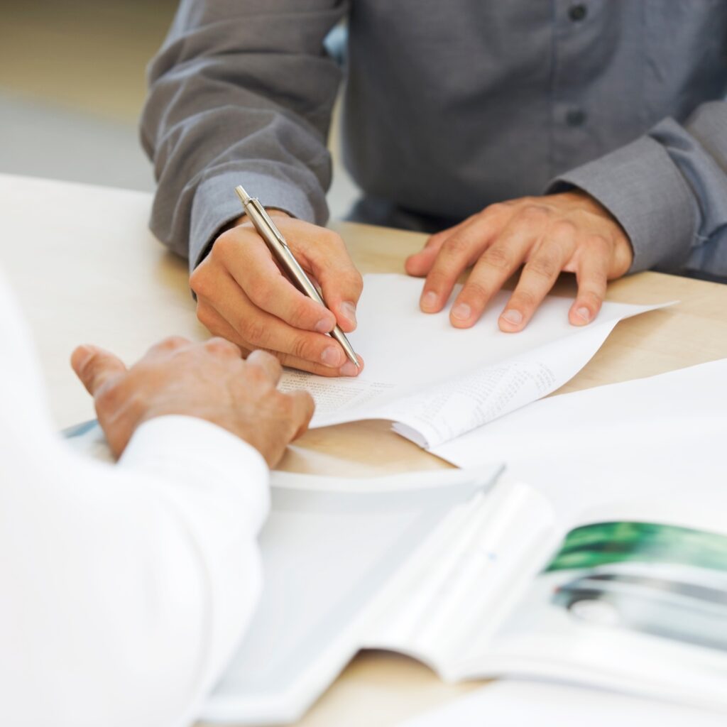 Perth Lawyer helps with Wills & Estate Planning: Man signing a document related to his estate; Clairs Keeley Lawyers Perth legal services.