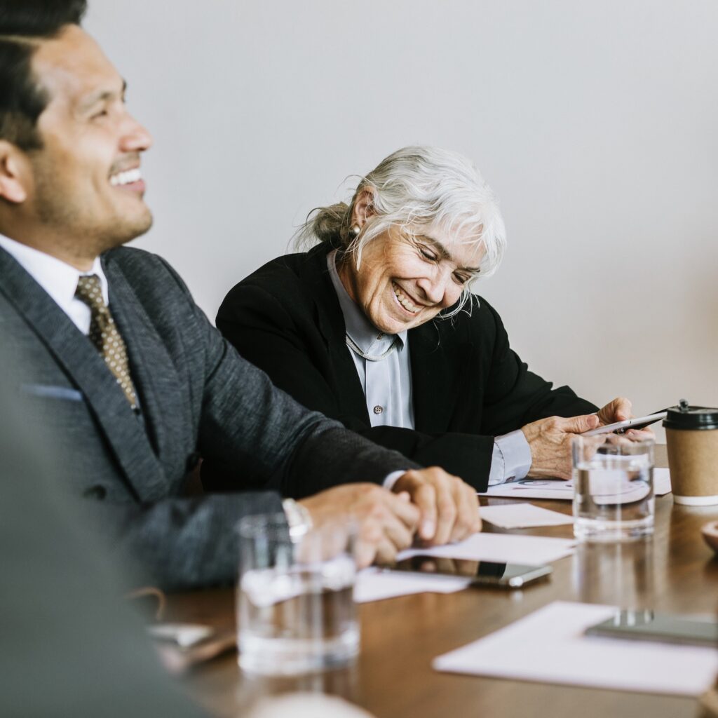 Boardroom meeting in Perth at Clairs Keeley Lawyers discussing Wills & Estate Planning; professionals smiling, business meeting atmosphere.