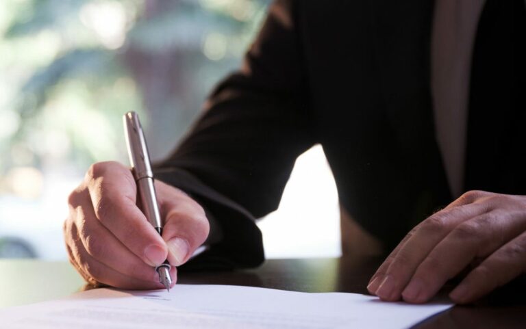 Businessman signing contract for Family Dispute Resolution with Clairs Keeley Lawyers in Perth, ensuring legal paper agreement.