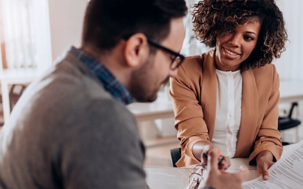 Couple at desk signing an agreement, possibly related to family dispute resolution services offered by Clairs Keeley Lawyers in Perth.