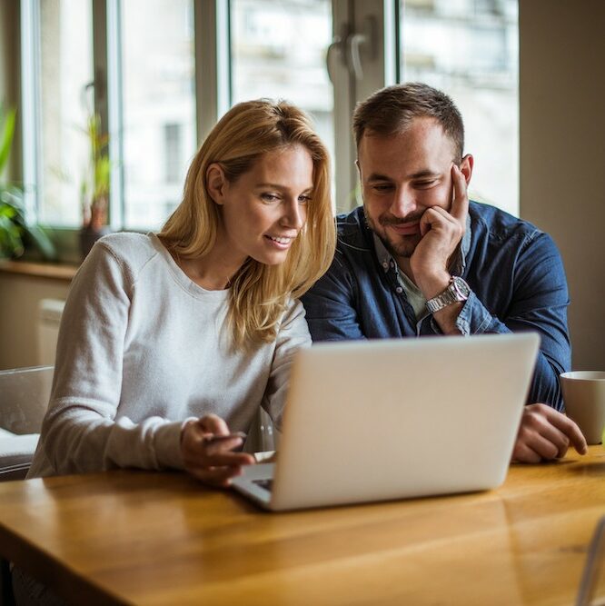 Perth couple reviews their de facto relationship info on a laptop. Clairs Keeley Lawyers assist with family & commercial law, estate planning.