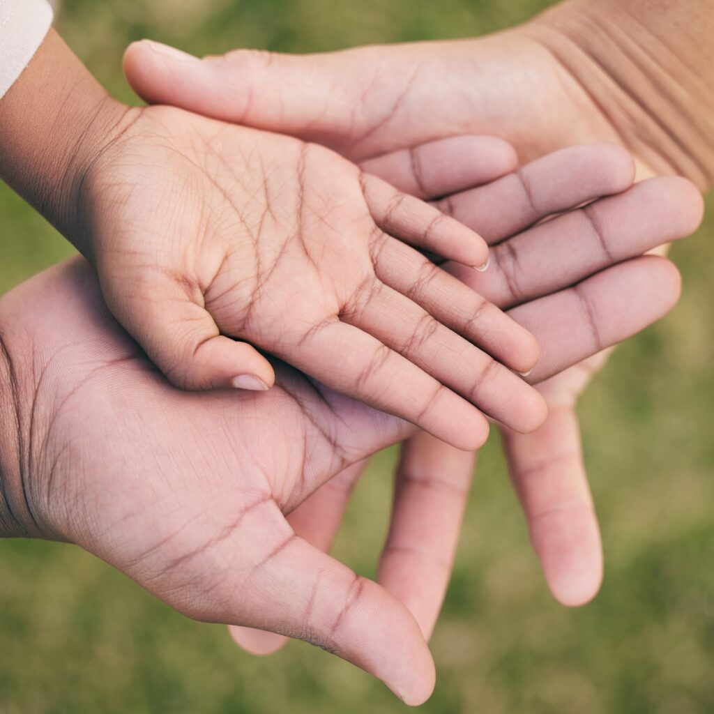 Family Bonding: Close-up of stacked hands, symbolizing family wills and estate planning services by Keeley Lawyers in Perth.