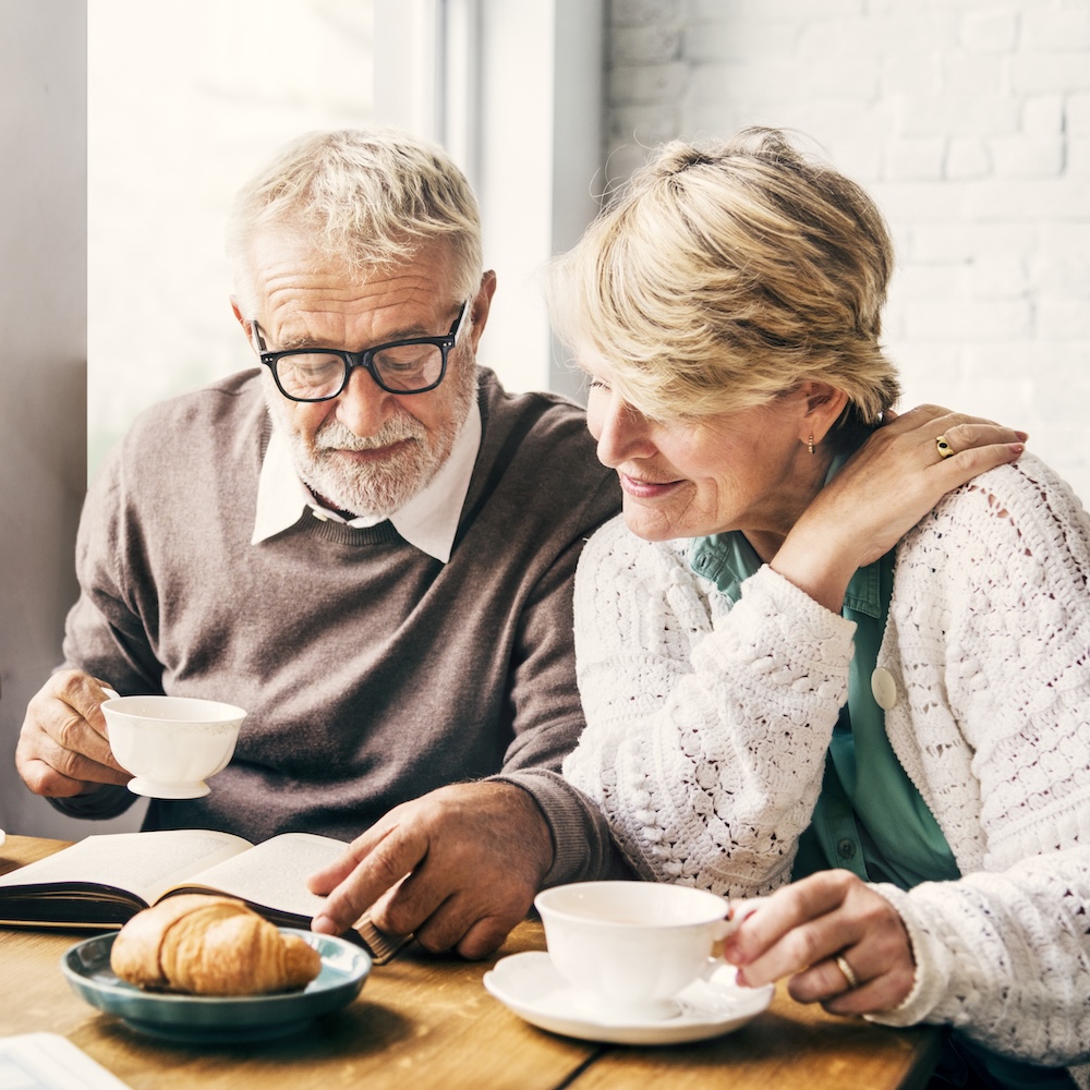 Senior couple in Perth reading about retirement & simple wills. Estate planning w/ Clairs Keeley Lawyers. Wills, estates, & probate assistance.