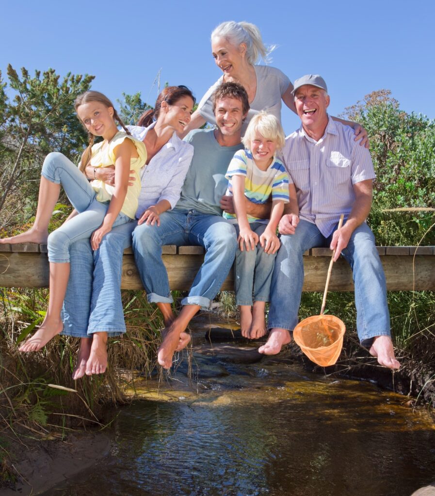 Wills & Estate Planning in Perth: Happy joint family sitting on bridge, symbolizing estate planning for families by Clairs Keeley Lawyers.