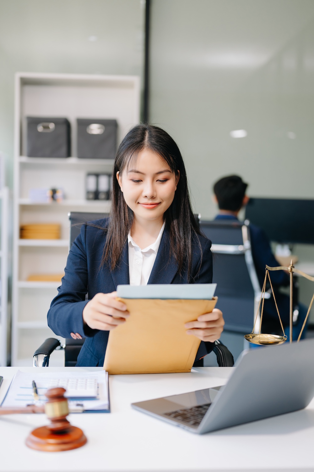 Perth Lawyer works on Grant of Probate, Wills & Estate papers, using laptop & gavel in office. Clairs Keeley Lawyers provide legal service.